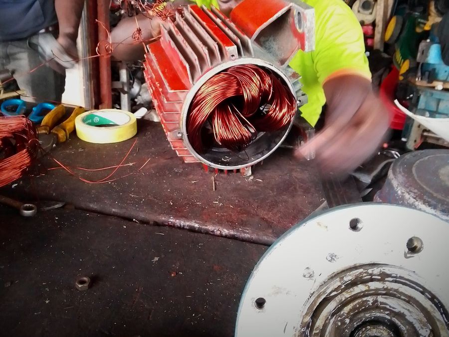 Rebobinage d’un stator de moteur : fils de cuivre en cours de pose